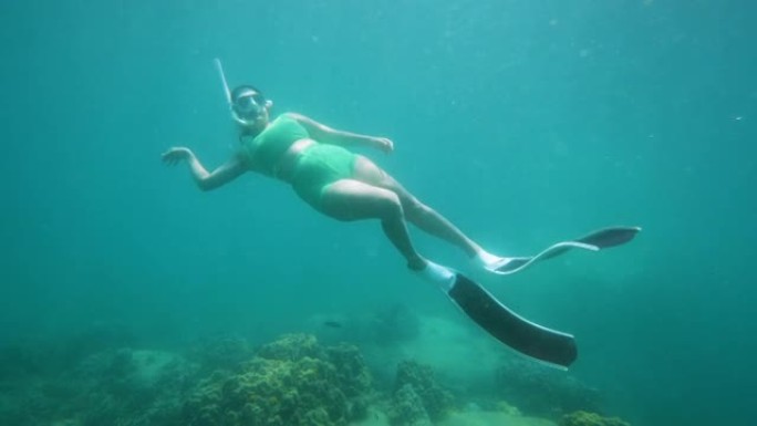 带鳍的自由潜水员在海洋水下滑行