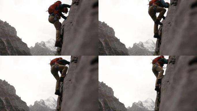 男性登山者登上陡峭的岩石面