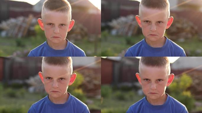 不满的孩子的肖像，一个愤怒的男孩脸上带着愤怒的表情看着相机。肖像悲伤的高加索男孩情绪愤怒，不满，沮丧
