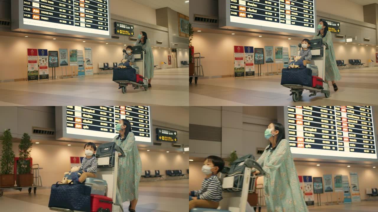 一个女人和儿子推着行李车来到机场的登机门。