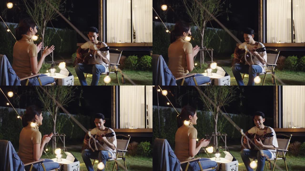 年轻夫妇一起在露营度假时弹吉他和唱歌