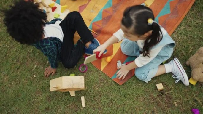 儿童团体在户外玩木制玩具。