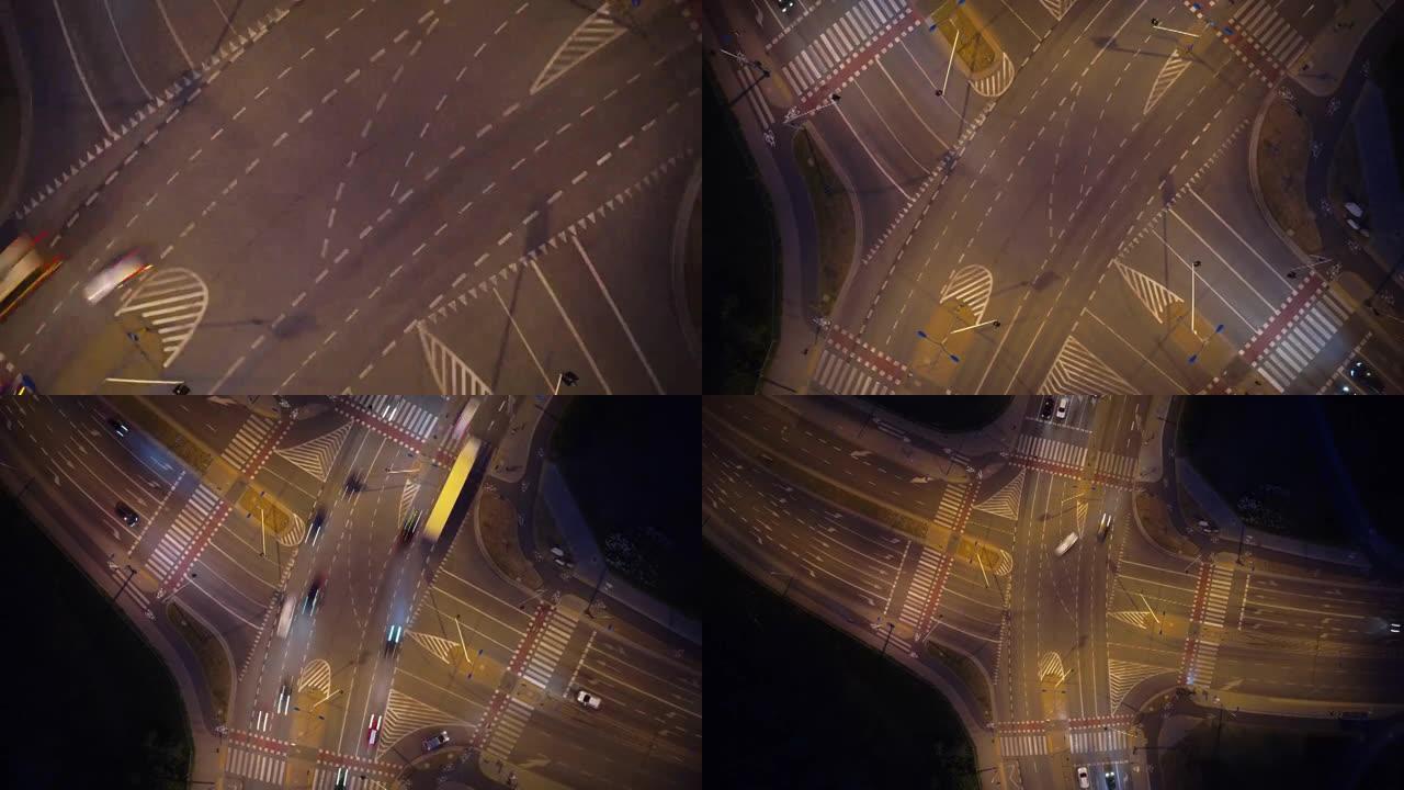 夜间城市交通过度。汽车在高速公路上四处行驶。大型照明交叉路口的鸟瞰图