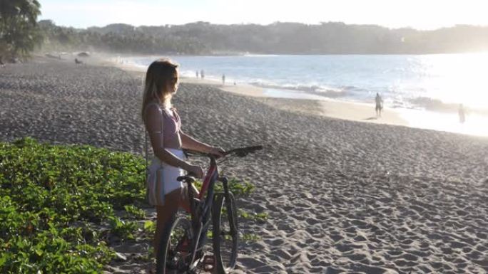 年轻女子在海滩上骑自行车放松