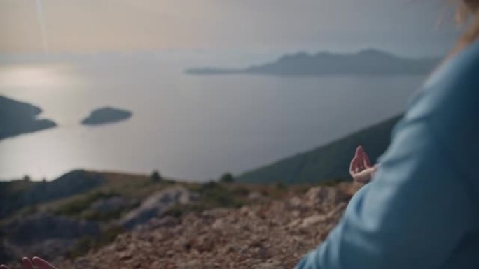 与自然的特写镜头。女人在海边落基山顶上的莲花姿势冥想