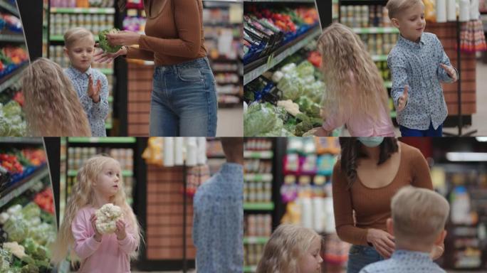 一位戴着防护面具的母亲带着两个孩子正在超市买杂货。与孩子一起购买食品蔬菜和水果