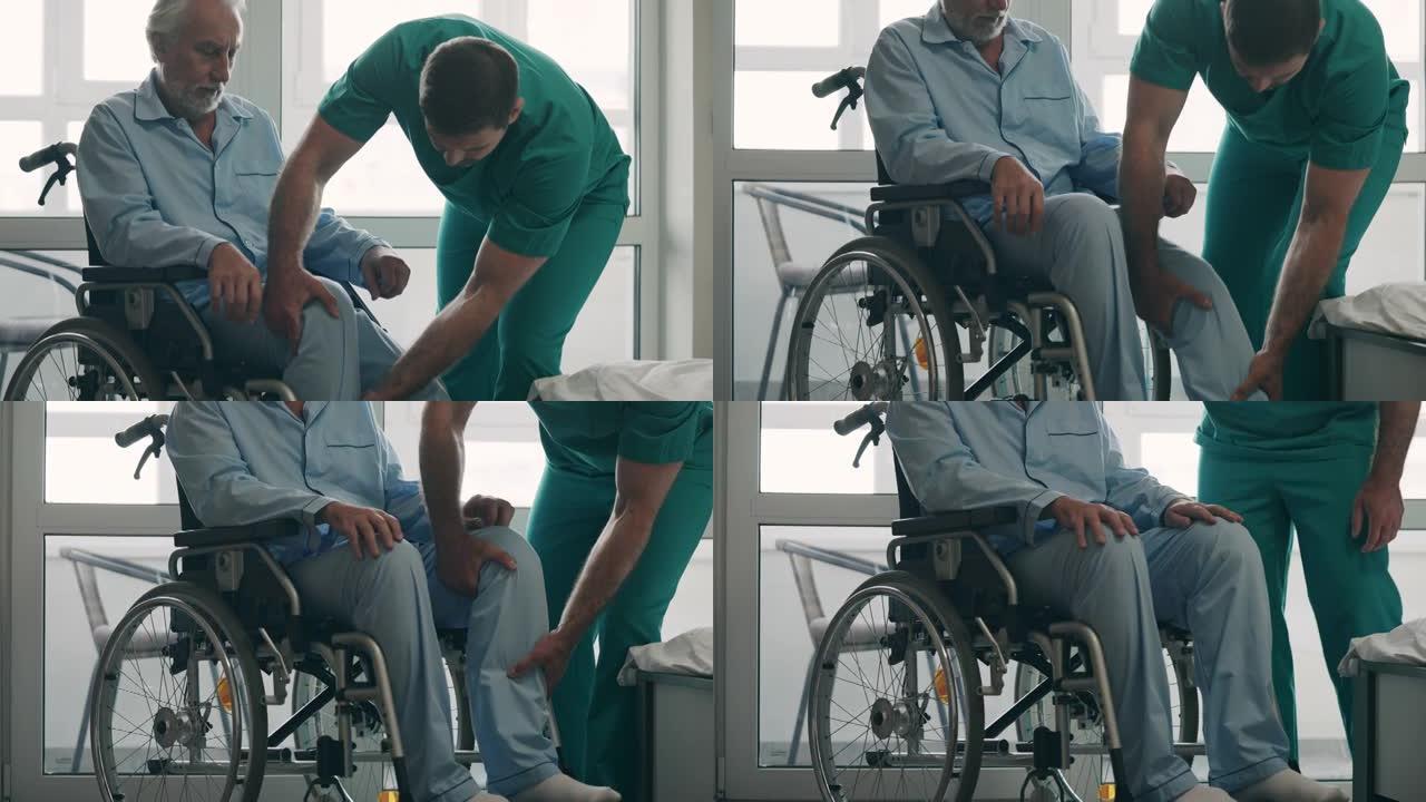 男医生帮助高级患者坐在轮椅上，创伤后康复