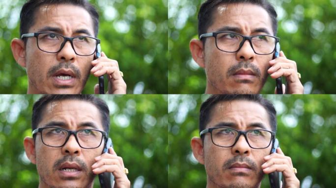 戴眼镜的男人在电话里聊天的特写镜头