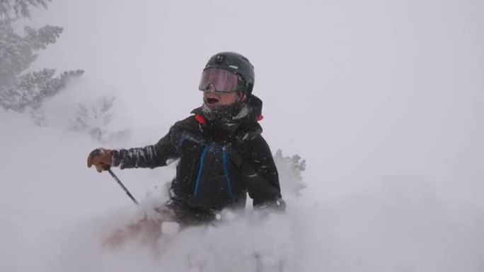 年轻人滑雪穿过完美的粉末雪