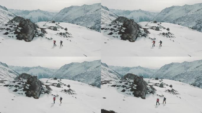 两名滑雪者在雪山上徒步旅行的空中无人机拍摄