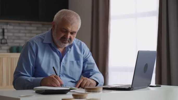 老人正在笔记本电脑中填写报告，财务专家或会计师正在家庭办公室工作