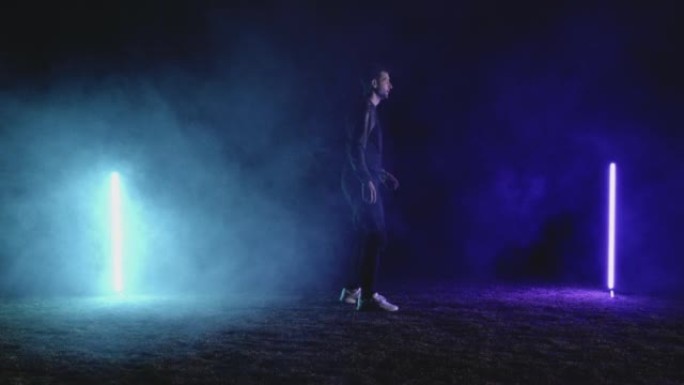足球运动员用霓虹灯对黑色进行技巧