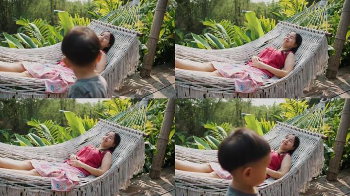 亚洲母亲和她的儿子坐在吊床上放松