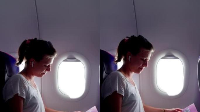 妇女乘飞机旅行时看着窗外，听音乐。