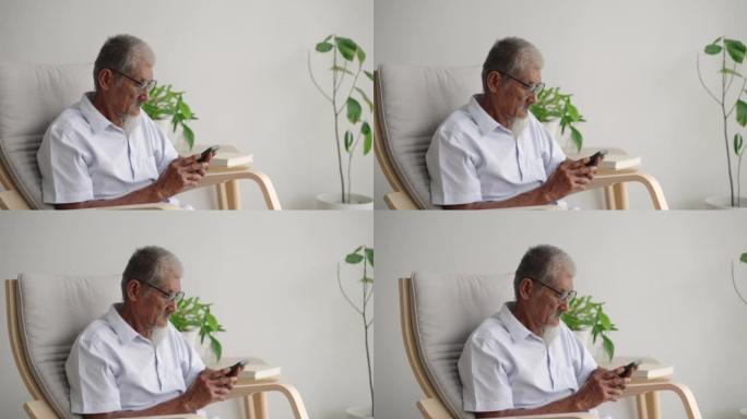 老年男子坐在扶手椅上使用电话休息