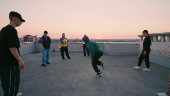 b-boy在屋顶上跳霹雳舞，在地板上旋转，表演技巧，青少年舞会