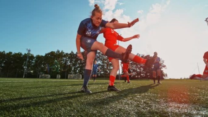 SLO MO女子足球运动员在阳光明媚的运动场上用力踢球