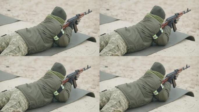 高角度视图，无法辨认的女性新兵躺在多边形瞄准。穿着制服在户外训练的白人女兵。军队生活方式和性别平等观