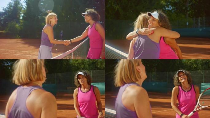 SLO MO两个女人在阳光明媚的日子里在外面打网球后握手拥抱