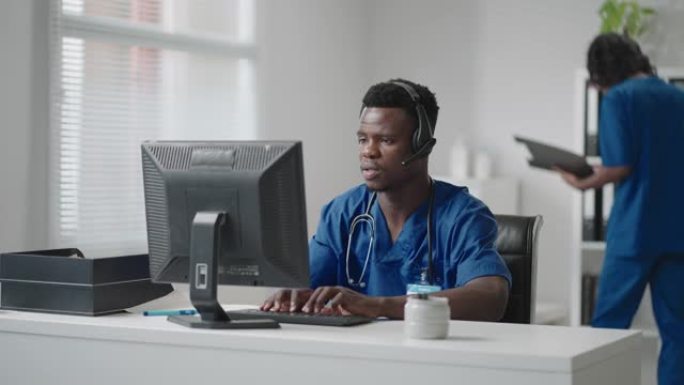 医生在线医疗咨询:非裔美国医生在台式电脑上与病人进行视频电话会议。
