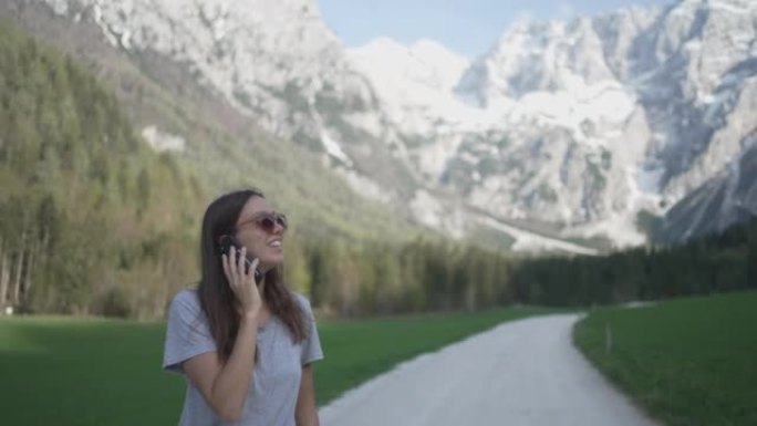 一名年轻女子在山里用手机说话的细节照片
