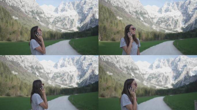 一名年轻女子在山里用手机说话的细节照片