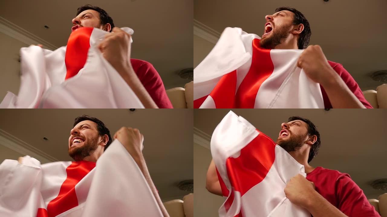 一名英国球迷在家里举着国旗庆祝