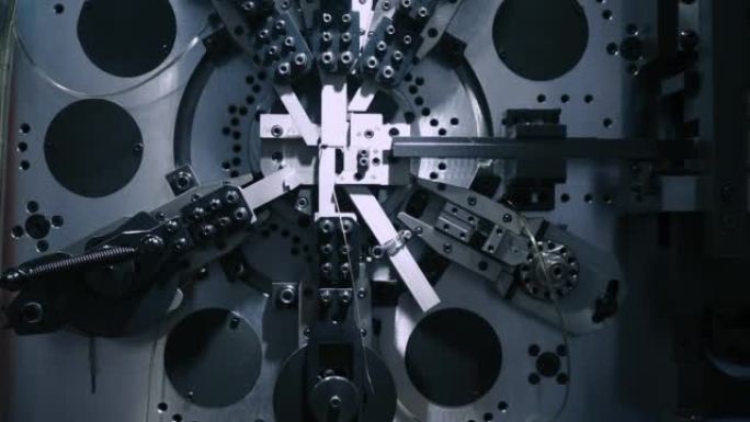 机器人自动机正在制造弹簧，CNC线圈孢子制造机，操作员在工厂制造汽车弹簧零件。