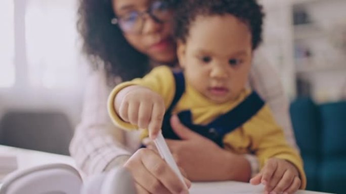 婴儿在商业文件上画画，坐在母亲的腿上，无薪育儿假