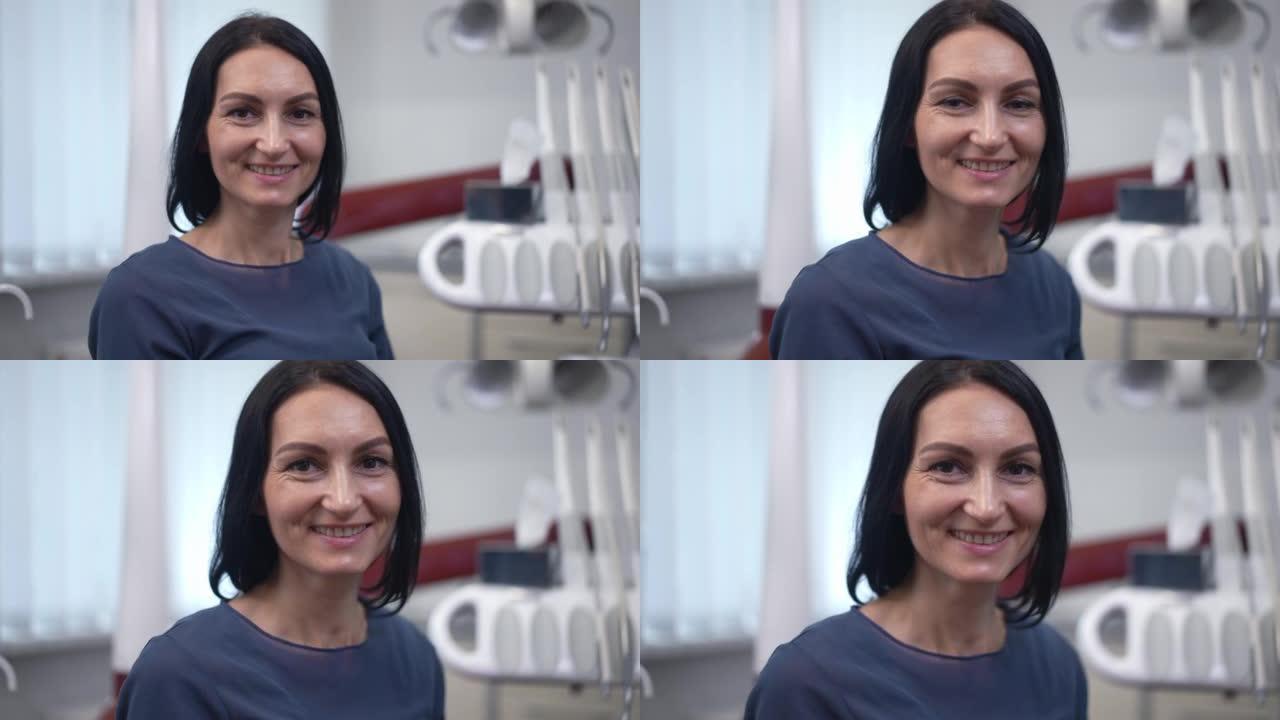自信满意的白人妇女在医院坐在牙科椅上看着相机的肖像。积极美丽的病人在室内诊所慢动作摆姿势。