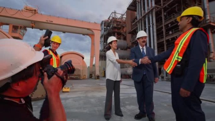 摄影师拍摄经理或政客与工人握手的照片