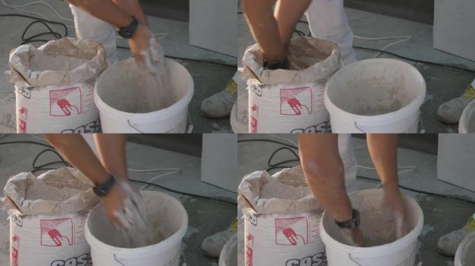 男子在桶中混合水泥的细节镜头
