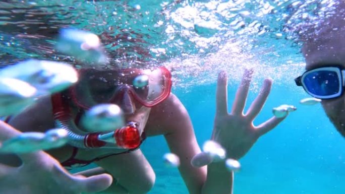 女人在海里浮潜。向可穿戴相机游泳，挥舞