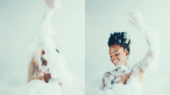 快乐美丽的非洲女人快乐跳舞覆盖着沐浴泡沫。慢动作，垂直拍摄。