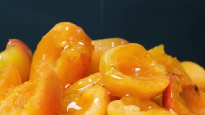 Honey is poured onto apricot slices.