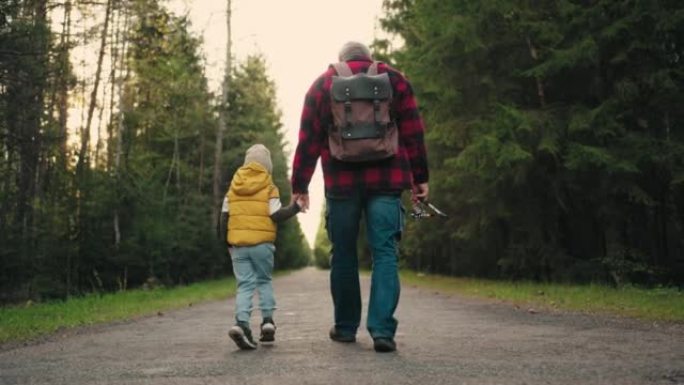 小男孩和他的爷爷早上步行去钓鱼，在针叶林风景如画的路上漫步