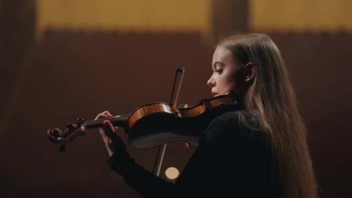 年轻女子在音乐学校练习拉小提琴，音乐厅女小提琴手的肖像