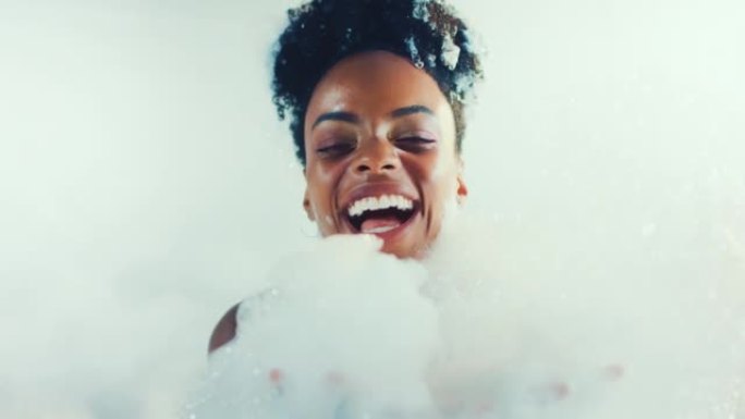 快乐美丽的非洲女人快乐而轻松地覆盖着沐浴泡沫。慢动作