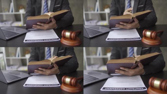 律师在办公室学习阅读法律书籍，旁边有锤子和笔记本电脑。4k视频。
