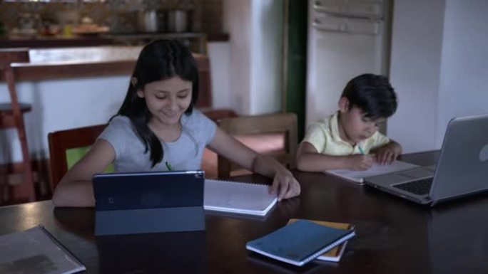 在covid-19封锁期间，专注的孩子在课堂上使用笔记本电脑和平板电脑