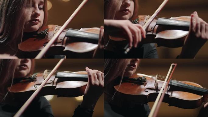 美丽的女小提琴手正在情绪化地演奏小提琴，脸部和小提琴的特写镜头，歌剧院的音乐会