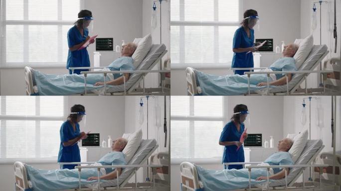 一名黑人女外科医生正在和一名躺在病床上的老年男性患者交谈。一名女性心脏病专家传染病专家正在诊所与患者