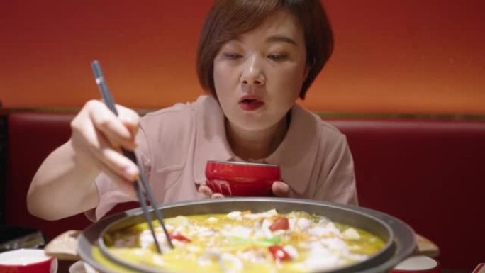 女人正在吃中国菜-酸汤中的鱼