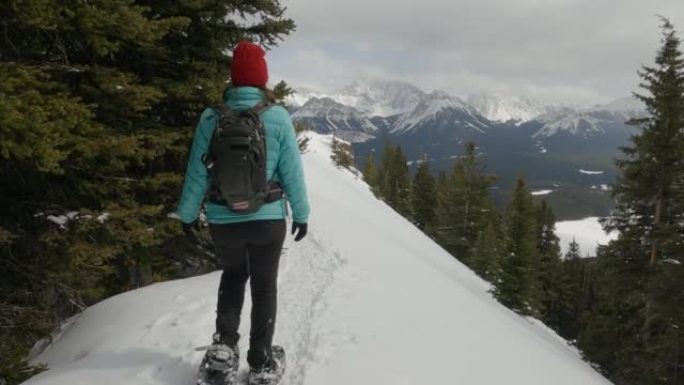 在山脊上，女人雪鞋行走的第一人称视角