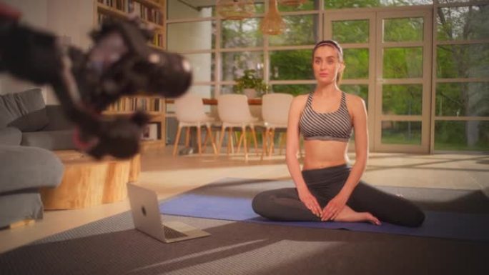 女运动员在家在瑜伽垫上锻炼。用相机制作教程。呼吸练习