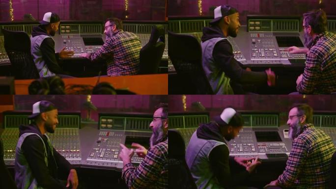 男嘻哈歌手在录音室里与唱片制作人一起听录音时说唱