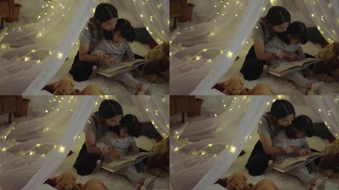 母亲在发光的帐篷里给女儿读书