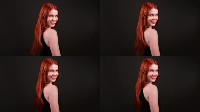 美丽的红发女人，留着健康的长发。用相机调情，微笑