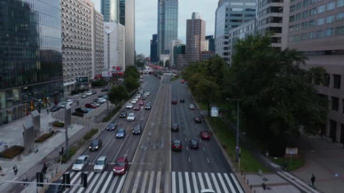 城市多车道道路上汽车行驶的前瞻性跟踪。高大的现代办公楼或公寓楼。波兰华沙