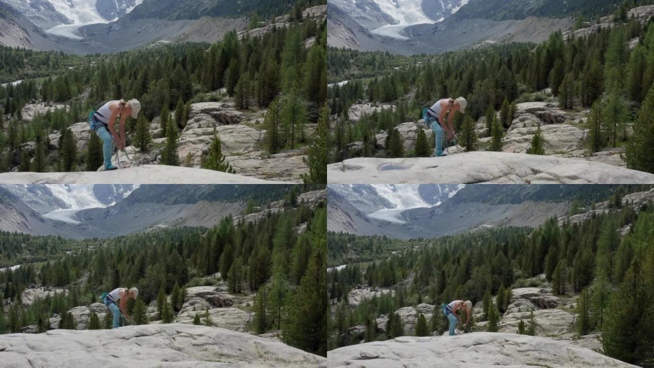 雌性登山者在岩石面上的垂降的无人机视图